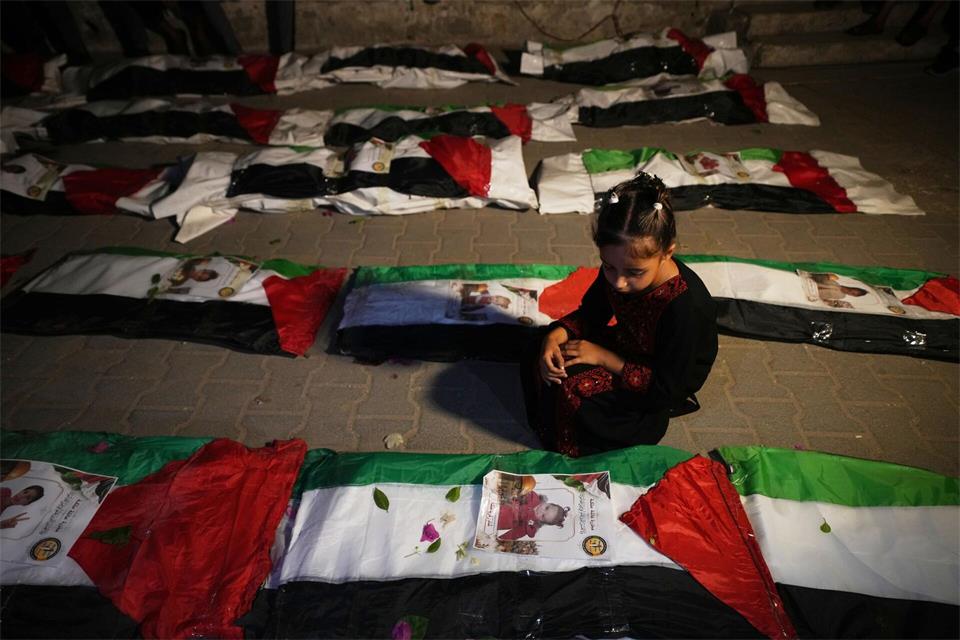 Ein Mädchen sitzt neben den Leichen von Palästinensern an, die aus den Trümmern von Häusern geborgen wurden, die während des Krieges zwischen Israel und der Hamas in Gaza Stadt zerstört worden waren.Jehad Alshrafi/AP/dpa
