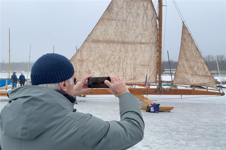 Ein Mann fotografiert auf dem zugefrorenen Müggelsee einen großen Eissegler. Lutz Deckwerth/dpa