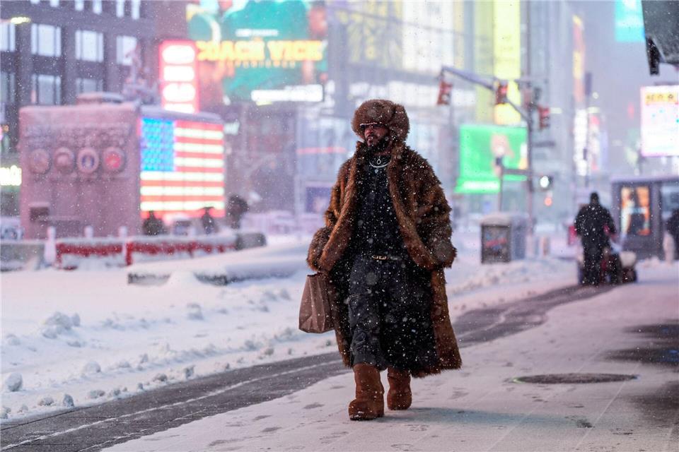 Ein Mann geht während eines Schneesturms über den Times Square in New York.Seth Wenig/AP/dpa