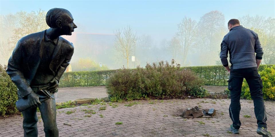 Ein Mann inspiziert den Dorfplatz in Wickede-Wiehagen, nachdem dort im April 2026 auch die zweite von drei Bronzefiguren des Bocholter Künstlers Jürgen Ebert gestohlen worden war.