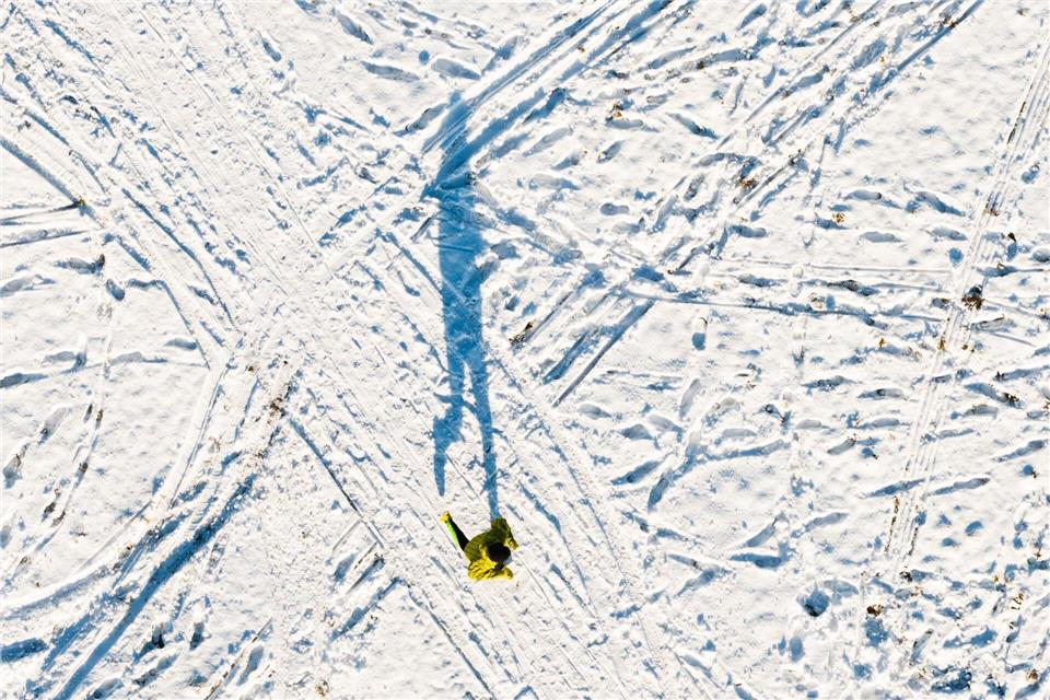 Ein Mann joggt am Kronsberg und wirft einen langen Schatten (Luftaufnahme mit Drohne).Julian Stratenschulte/dpa