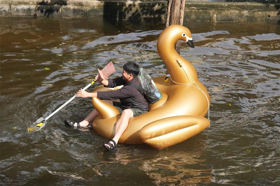 Ein Mann paddelt nach tagelangen starken Regenfällen auf einem Schwimmtier in Form eines goldenen Schwans durch eine überflutete Straße in der thailändischen Hauptstadt.Sakchai Lalit/AP/dpa