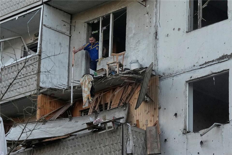 Ein Mann räumt in Kiew Trümmer an seinem Wohnhaus raus, das nach einem russischen Raketeneinschlag beschädigt wurde.Efrem Lukatsky/AP/dpa