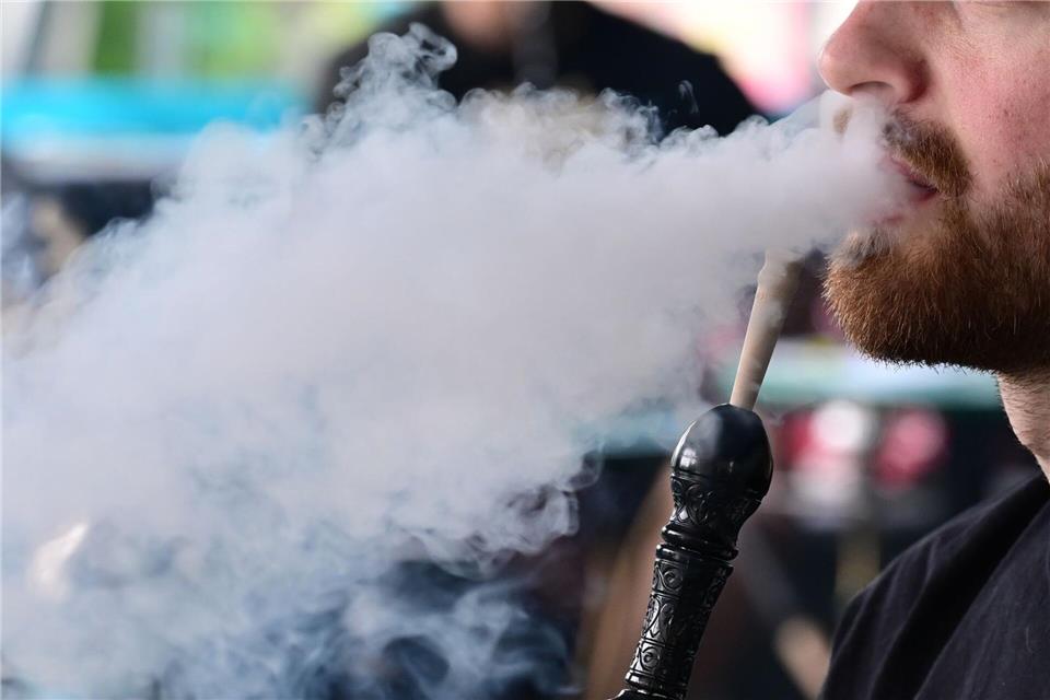 Ein Mann raucht in einer Shisha-Bar eine Wasserpfeife.Bernd Weißbrod/dpa