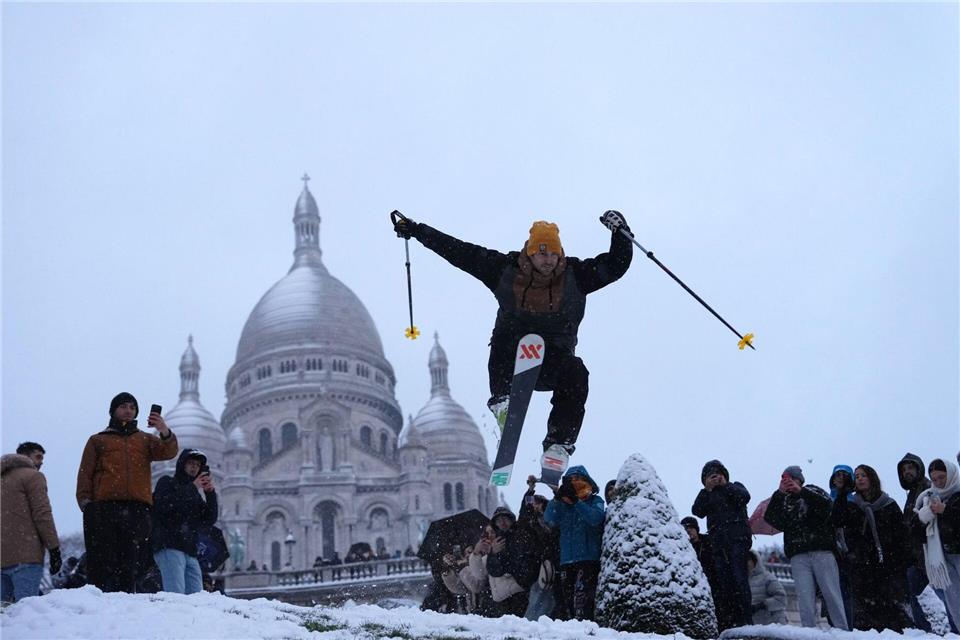 Ein Mann springt mit seinen Skiern den Hügel bei der Basilika Sacre-Coeur im französischen Paris hinunter.Aurelien Morissard/AP/dpa