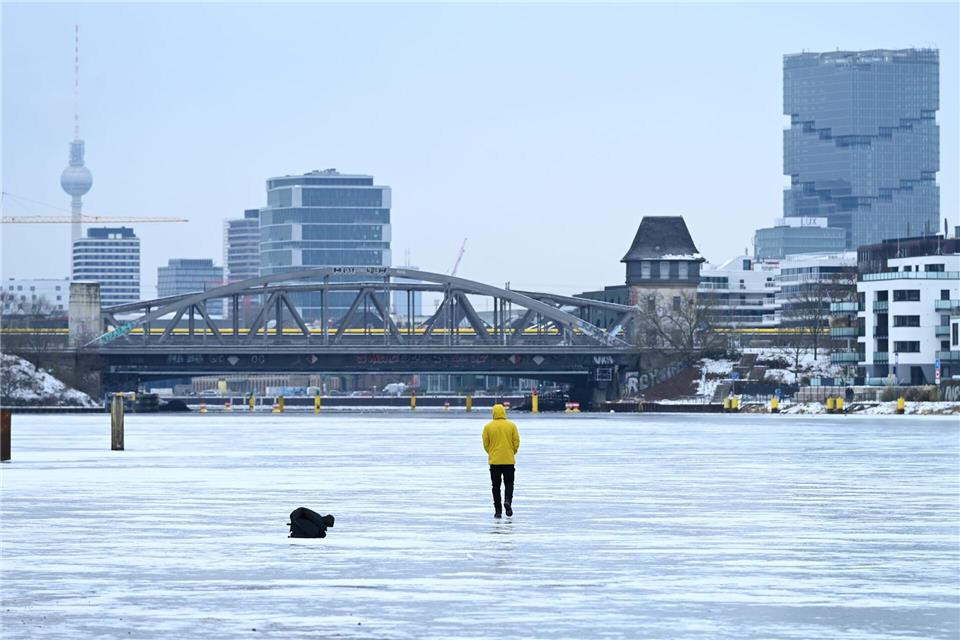 Ein Mann steht am Treptower Park in Berlin auf der zugefrorenen Spree.Elisa Schu/dpa