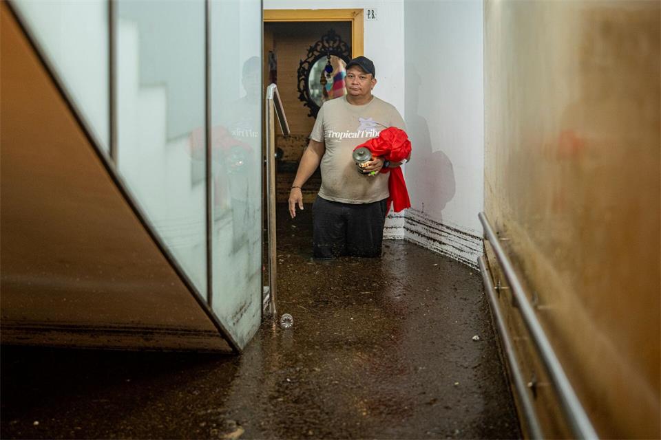 Ein Mann steht im Treppenhaus eines Gebäudes in der an Barcelona grenzenden Stadt L’Hospitalet de Llobregat in mehr als knietiefem Wasser. Lorena Sopêna/EUROPA PRESS/dpa