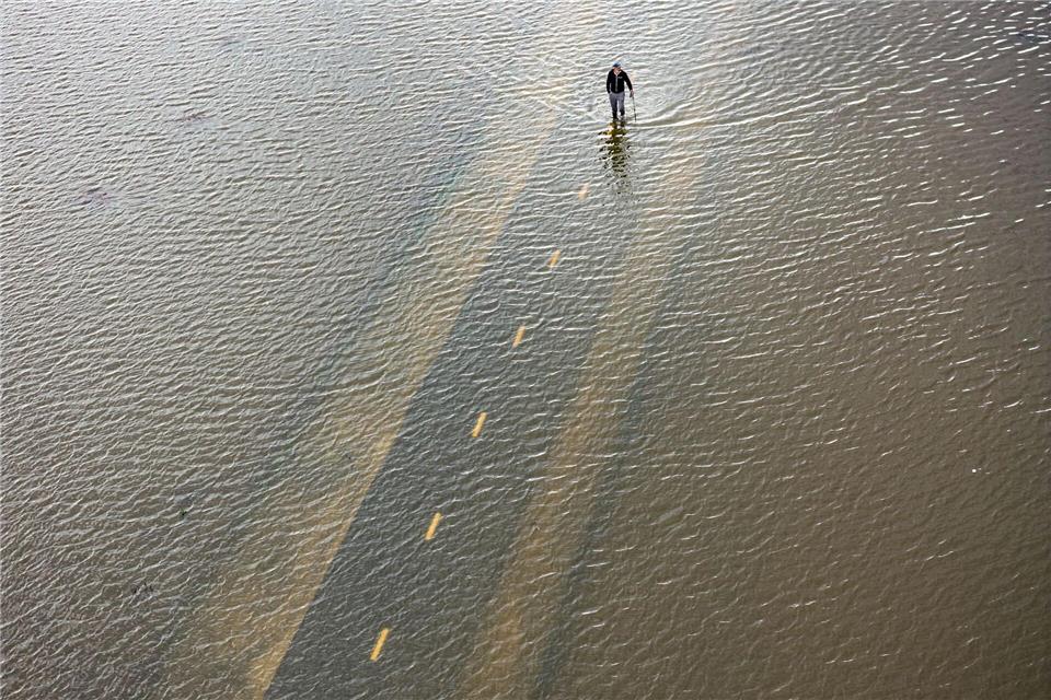 Ein Mensch geht auf einem überfluteten Weg während einer Springflut in Kalifornien.Ethan Swope/FR171736 AP/AP/dpa