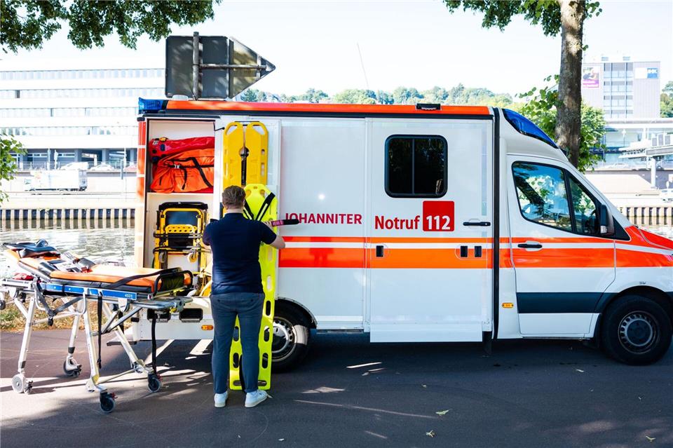 Ein Mitarbeiter der Johanniter-Unfall-Hilfe bereitet eine Station neben einem Rettungswagen vor.Laszlo Pinter/dpa