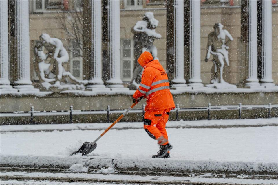Ein Mitarbeiter der Stadtreinigung Potsdam befreit eine Tram-Haltestelle vom Schnee.Georg Moritz/dpa