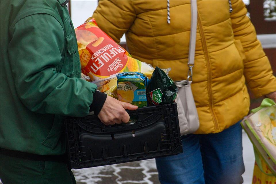Ein Mitarbeiter der Tafel in Zerbst trägt Lebensmittelkisten zu den Kunden.Klaus-Dietmar Gabbert/dpa