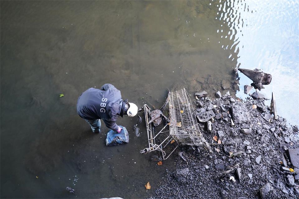 Ein Mitarbeiter des Landesbetriebs Straßen, Brücken und Gewässer reinigt den fast wasserleeren Alsterfleet. (Archivbild)Marcus Brandt/dpa