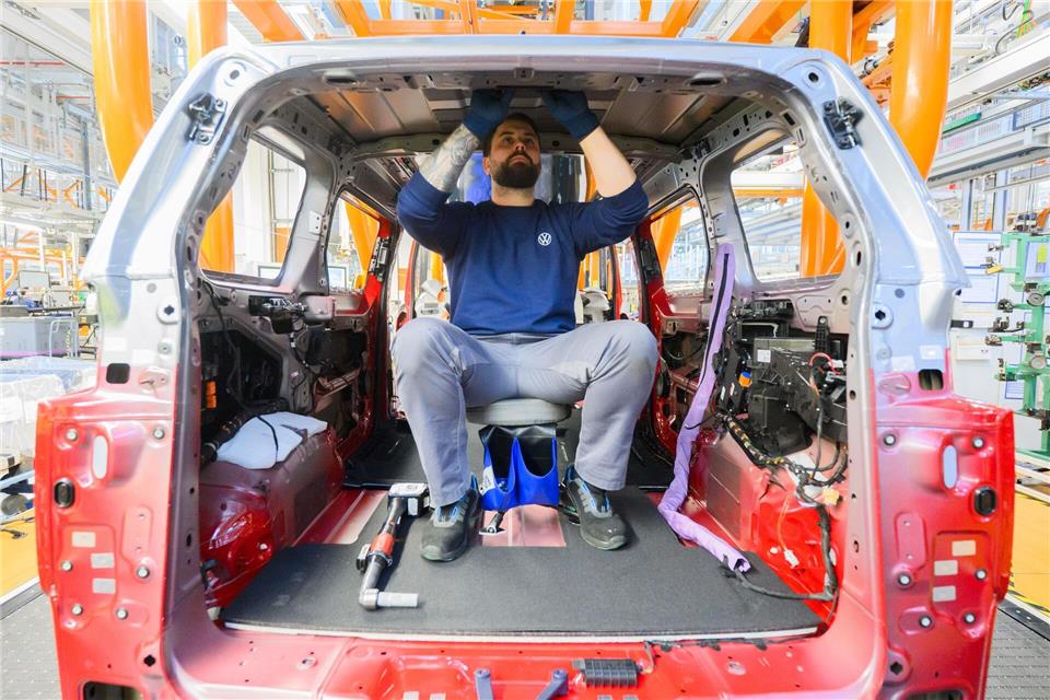 Ein Mitarbeiter montiert einen Elektro-Bulli ID. Buzz im Werk von Volkswagen Nutzfahrzeuge. Julian Stratenschulte/dpa