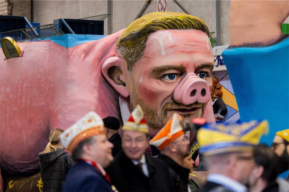 Ein Motivwagen, der Christian Lindner als Sparschwein mit der Schuldenbremse zeigt, steht beim Richtfest für den Rosenmontagszug im Karnevalsmuseum.