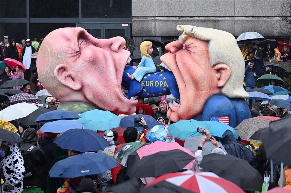 Ein Mottowagen mit Putin und Trump, die versuchen Europa zu fressen, fährt an den Zuschauern beim Rosenmontagszug in Düsseldorf vorbei. Federico Gambarini/dpa