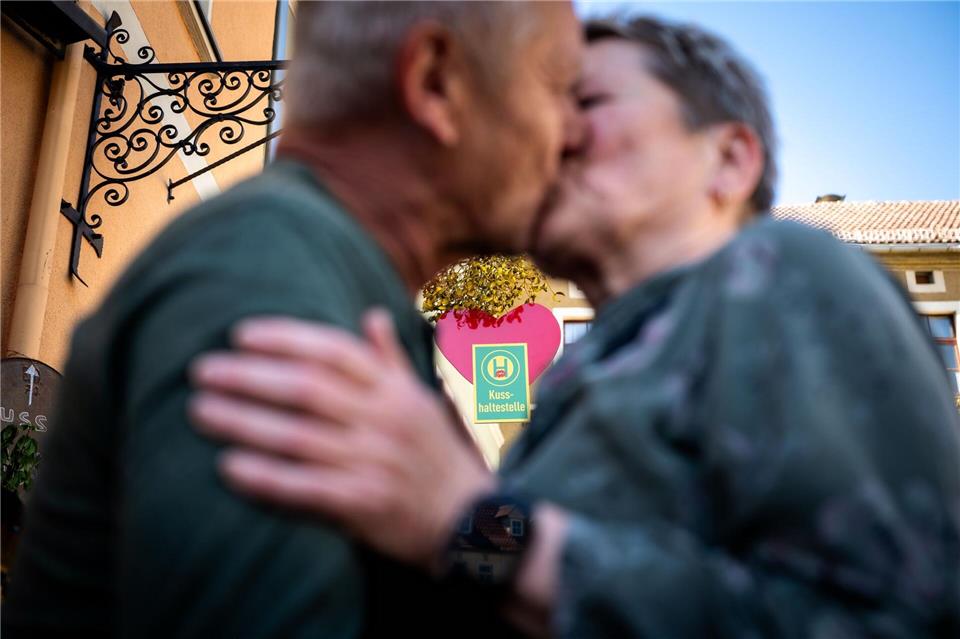 Ein Paar küsst sich an der Eisenberger „Kusshaltestelle“. Jacob Schröter/dpa