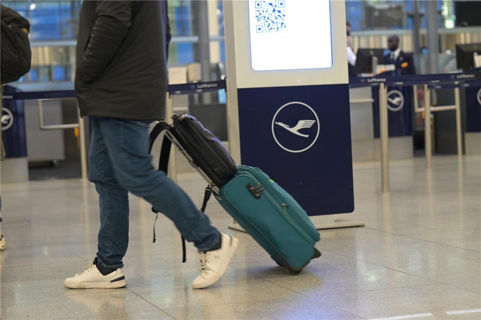 Ein Passagier läuft an einem Lufthansa-Schalter vorbei. Bei der Lufthansa gehen am Donnerstag Piloten und Flugbegleiter gleichzeitig in einen ganztägigen Streik.Malin Wunderlich/dpa