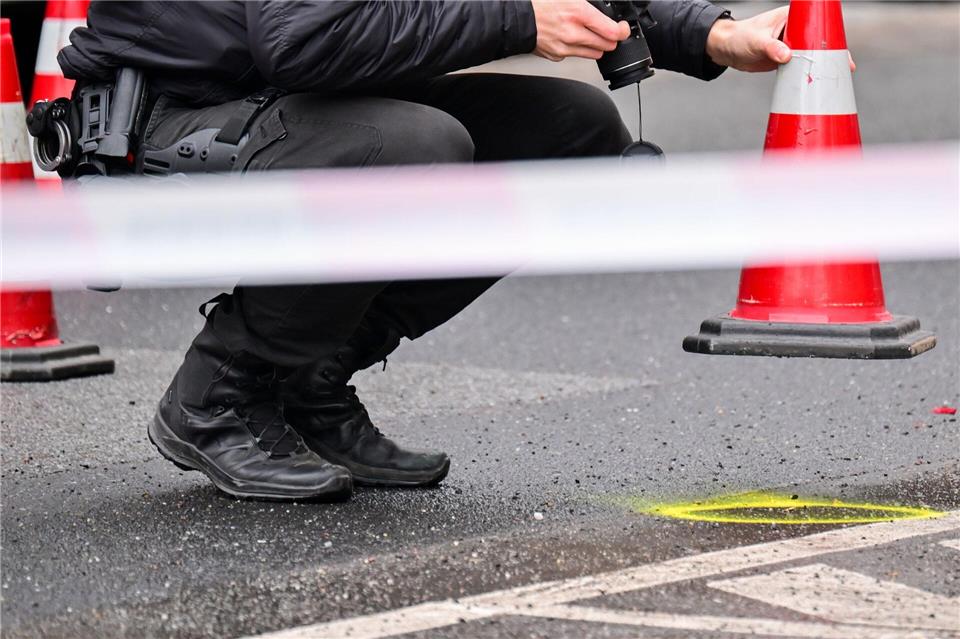 Ein Polizeibeamter fotografiert ein Beweismittel auf der Straße. (Archivbild) Sebastian Gollnow/dpa