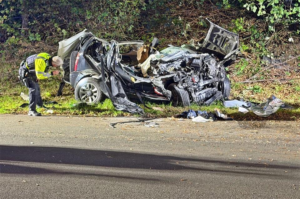 Ein Polizeibeamter untersucht das zerstörte Fahrzeug nach dem Unfall.Gianni Gattus/dpa