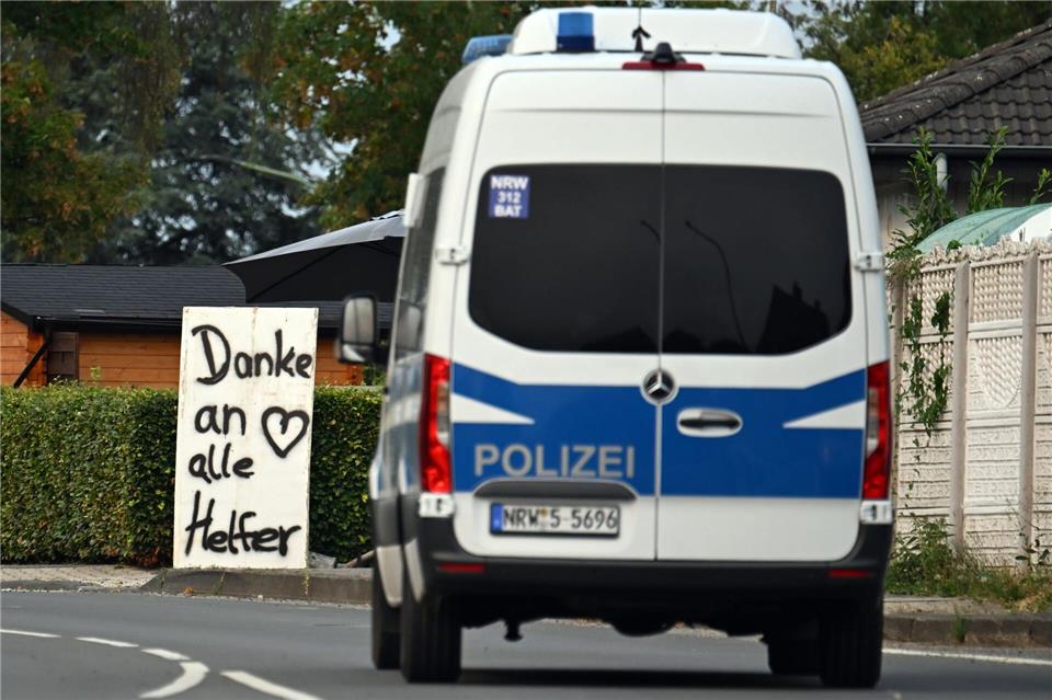 Ein Polizeifahrzeug fährt an einem Schild mit der Aufschrift „Danke an alle Helfer“ vorbei. Federico Gambarini/dpa
