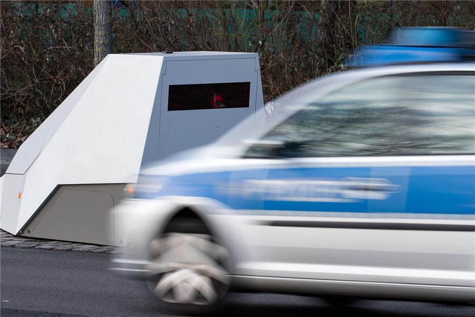 Ein Polizeiwagen fährt an einem mobilen Blitzwagen, einem Geschwindigkeitsmessanhänger vorbei. (Symbolbild)Bernd von Jutrczenka/dpa