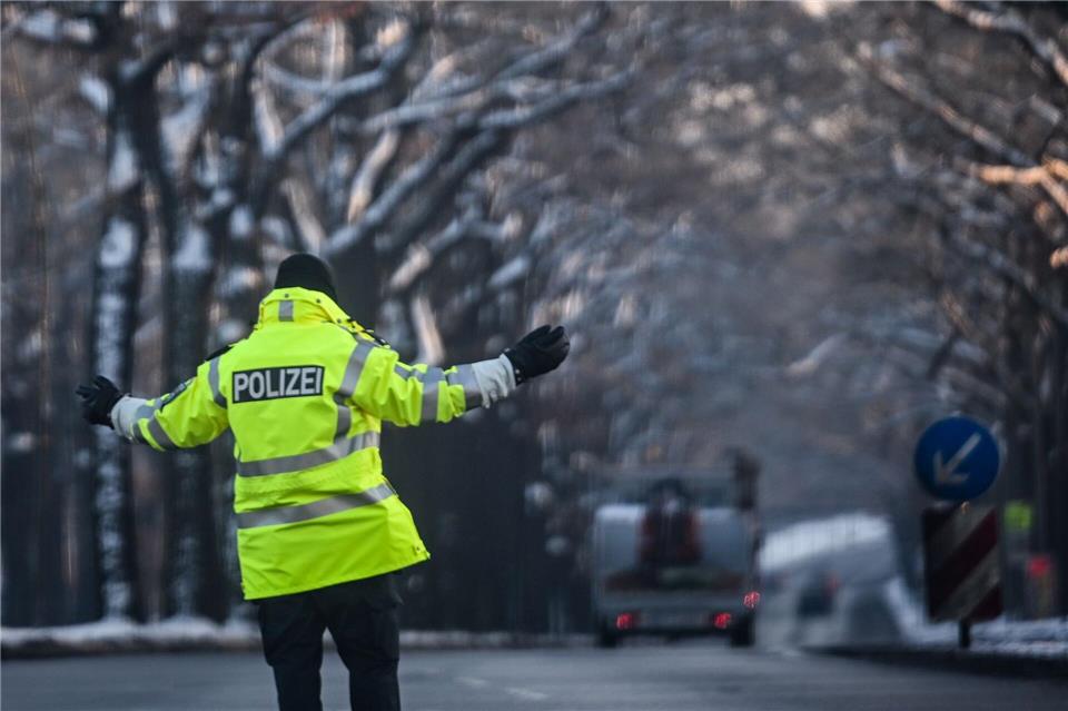 Ein Polizist regelt den Verkehr an einer Kreuzung, an der die Ampel ausgefallen ist. Britta Pedersen/dpa