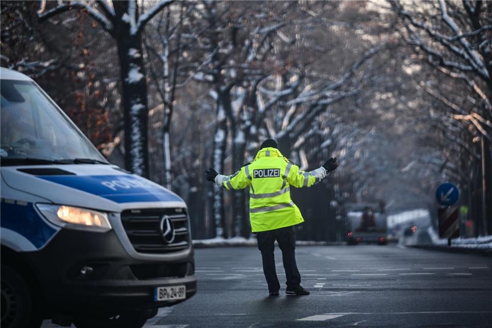 Ein Polizist regelt den Verkehr an einer Kreuzung, an der die Ampel ausgefallen ist.Britta Pedersen/dpa