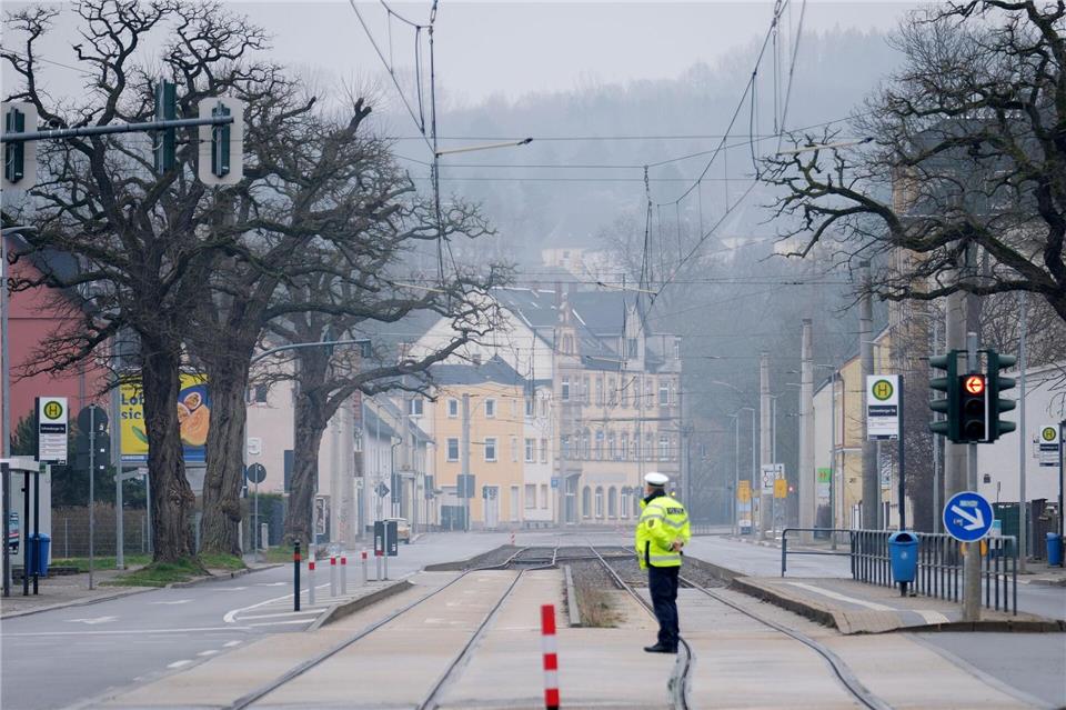 Ein Polizist steht auf einer Kreuzung im Stadtteil Altchemnitz. Wegen der geplanten Entschärfung Weltkriegsbombe müssen hier viele Einwohner ihre Häuser verlassen. Sebastian Willnow/dpa
