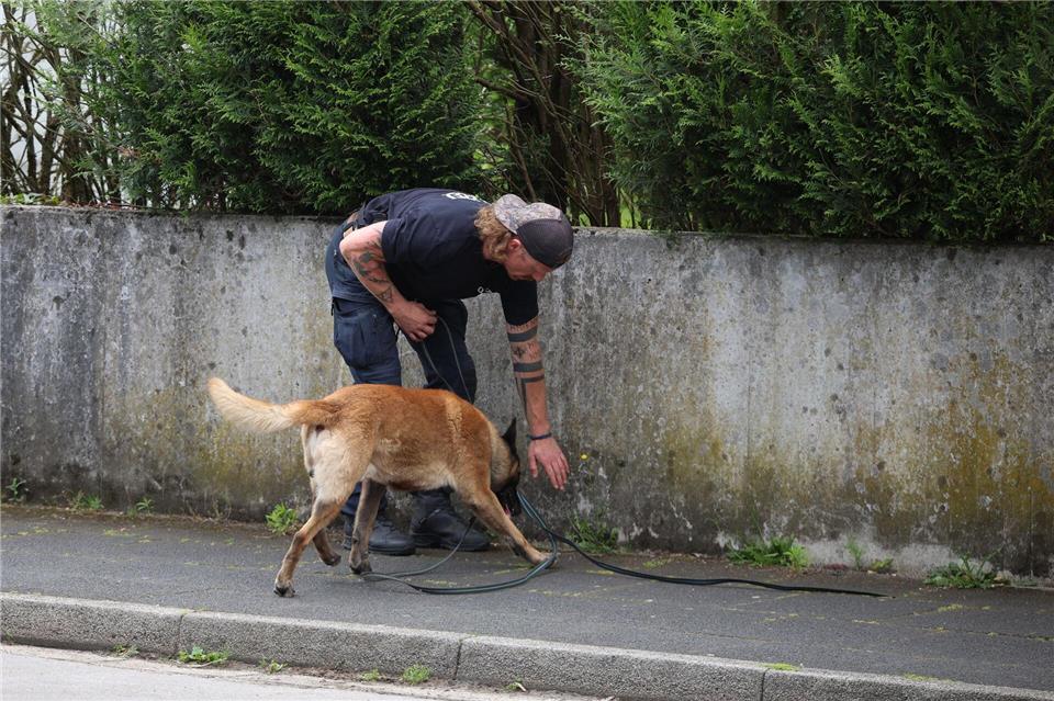 Ein Polizist sucht mit einem Spürhund nach Hinweisen.Christoph Reichwein/dpa