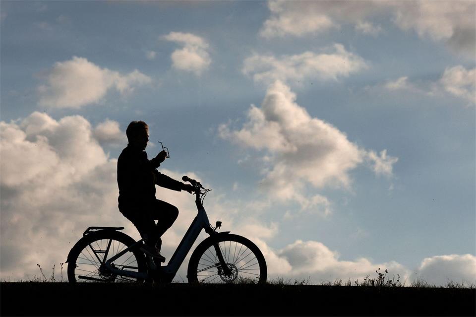 Ein Radfahrer ist mit seinem Fahrrad auf der Dammkrone des Stausees Kelbra unterwegs.Matthias Bein/dpa