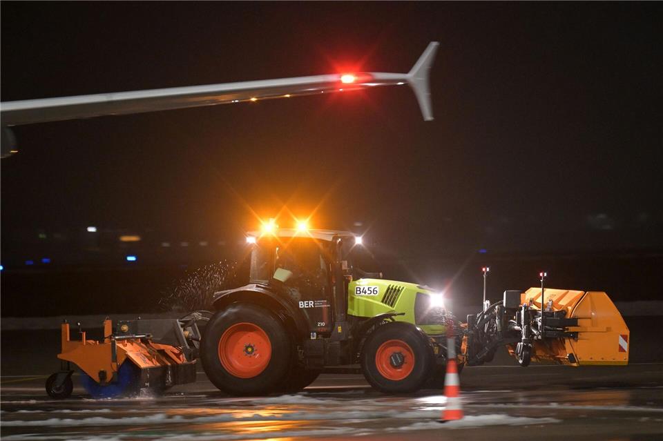 Ein Räumfahrzeug fährt über das Flugfeld des Berliner Flughafen BER.Michael Bahlo/dpa