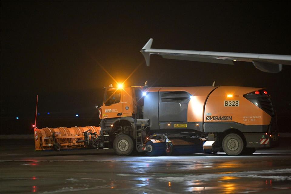 Ein Räumfahrzeug fährt über das Flugfeld des Berliner Flughafen BER. (Archivbild) Michael Bahlo/dpa