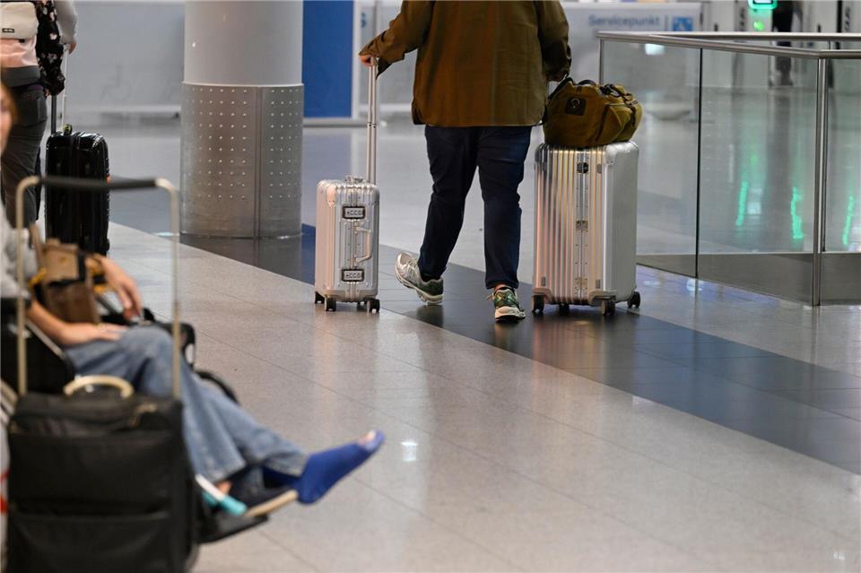 Ein Reisender schiebt seine Koffer im Abflug-Terminal des Flughafens Düsseldorf. (Symbolbild)Roberto Pfeil/dpa