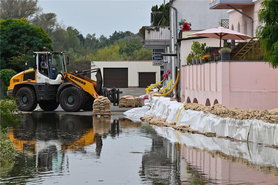 Ein Sandsack-Wall wird in einem Stadtteil von Eisenhüttenstadt verstärkt. Dort hat das Hochwasser Straßen überflutet.Patrick Pleul/dpa