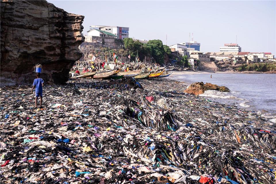 Ein Sandstrand, dessen Sand gar nicht mehr zu sehen ist: Massen an Klamotten vermüllen diesen Küstenabschnitt von Accra. Kevin McElvaney/Deutsche Umwelthilfe/dpa