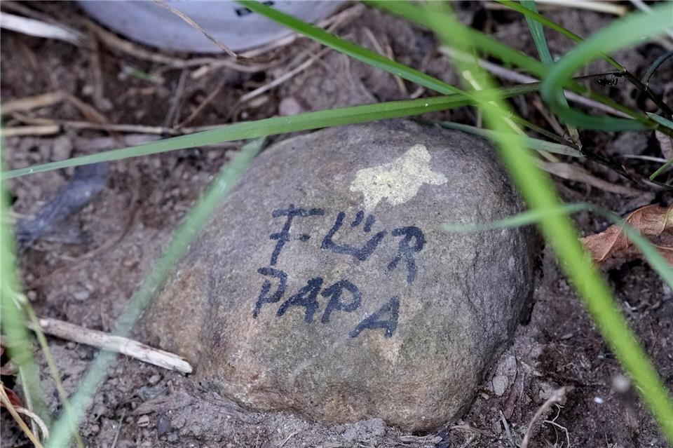 Ein Stein mit der Aufschrift „Für Papa“ liegt am Ufer der Mulde im Ortsteil Bahren.Sebastian Willnow/dpa