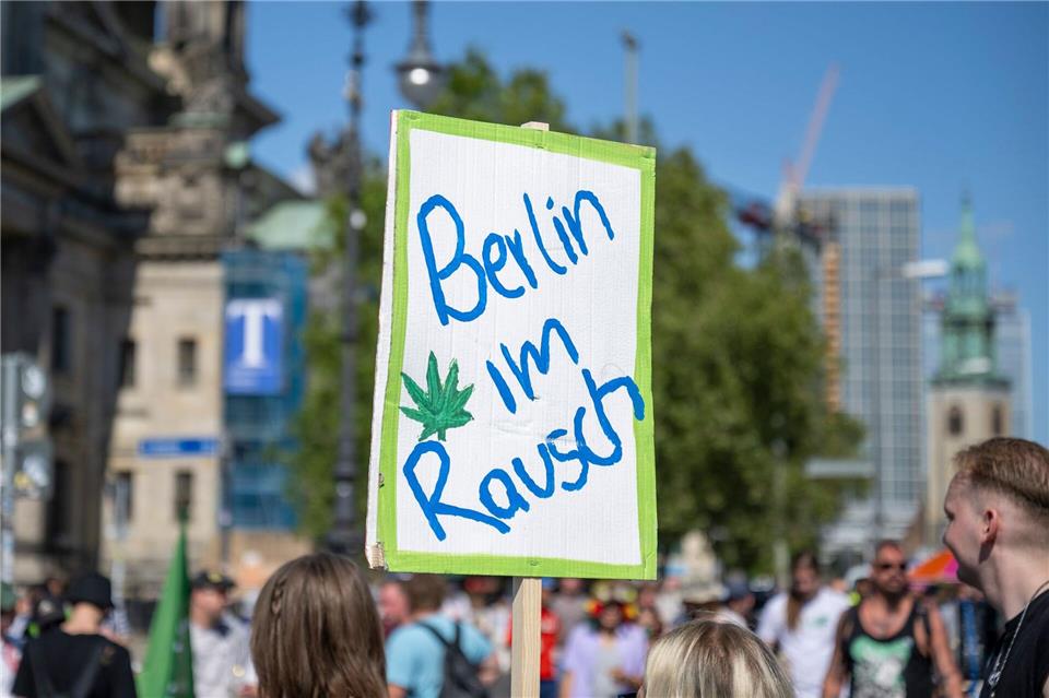 Ein Teilnehmer der Hanfparade mit einem Plakat mit der Aufschrift „Berlin im Rausch“.Christophe Gateau/dpa