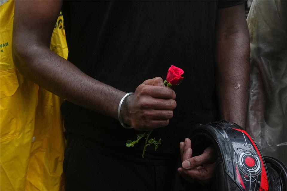Ein Teilnehmer einer Demonstration hält während einer Kundgebung für Bildungsreformen im Rahmen der anhaltenden Protestbewegung der „Cockroach Janta Party“ eine Blume in der Hand.Rafiq Maqbool/AP/dpa