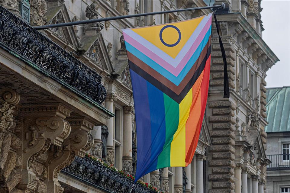 Ein Trauerflor ist an der Pride-Fahne vor dem Hamburger Rathaus angebracht.Markus Scholz/dpa