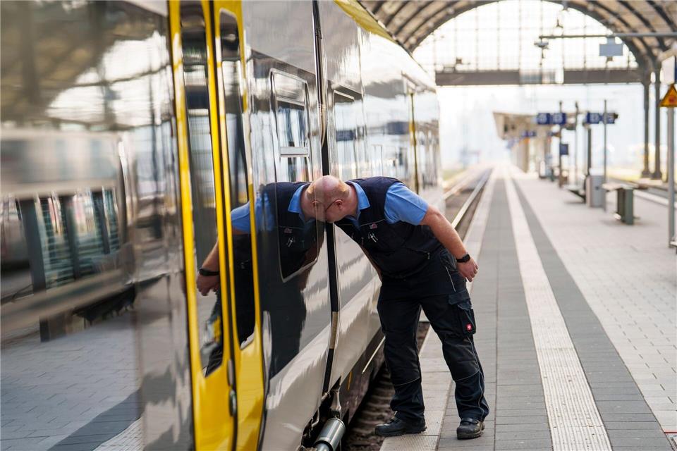 Ein Triebwagenführer überprüft die angekoppelten Wagen am Batteriezug.Andreas Arnold/dpa