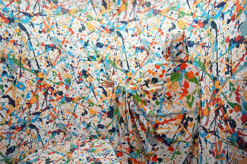 Ein Umhang lässt eine Besucherin in einer optischen Täuschung unsichtbar erscheinen.Marcus Brandt/dpa