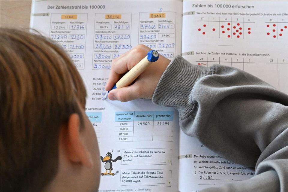 Ein Viertklässler arbeitet in seinem Matheheft. (Symbolbild)Bernd Weißbrod/dpa