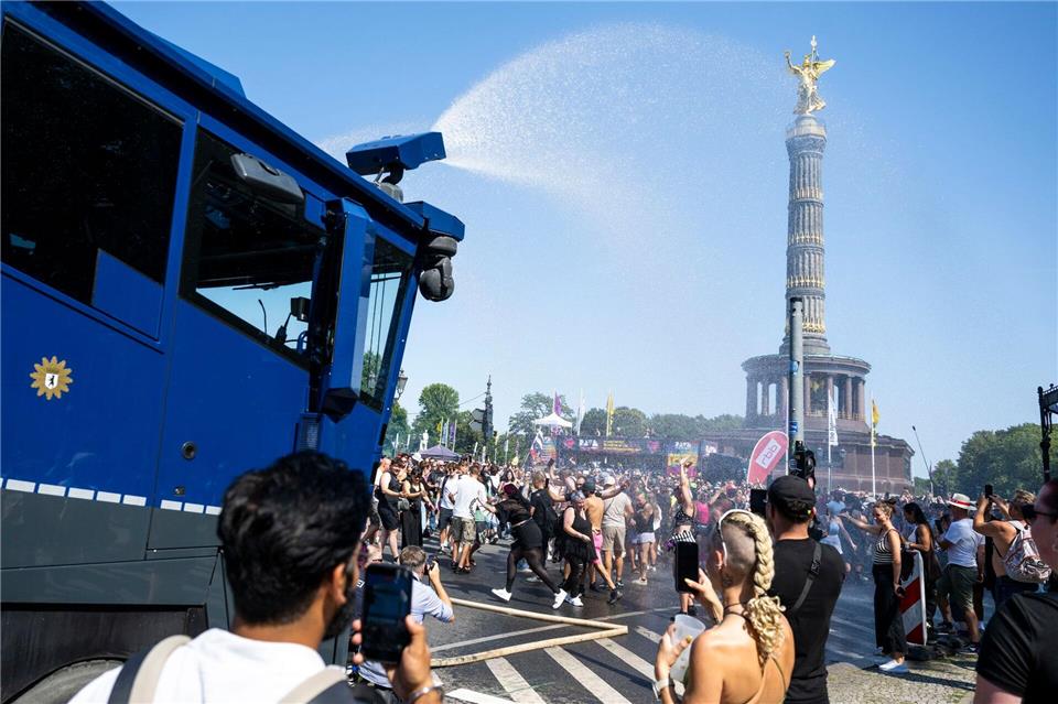 Ein Wasserwerfer der Polizei verschafft den Ravern etwas Abkühlung.  Christophe Gateau/dpa