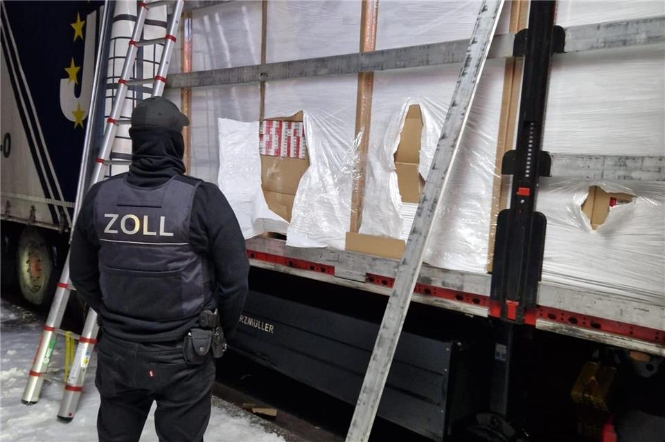 Ein Zöllner steht vor einem mit Zigaretten beladenem Lkw.Zoll Hannover/dpa