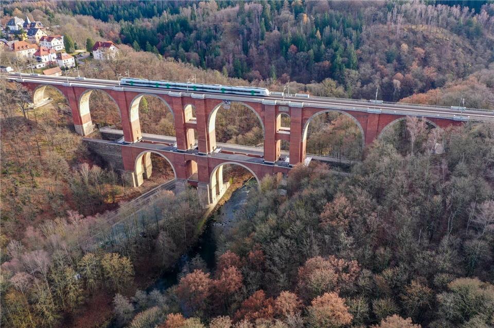 Ein Zug der Vogtlandbahn fährt über die historische Elstertalbrücke im Vogtland. Sie ist die zweitgrößte Ziegelsteinbrücke der Welt (Luftaufnahme mit Drohne). Jan Woitas/dpa