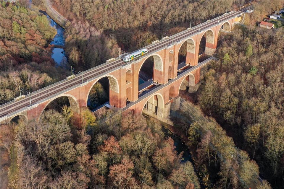 Ein Zug fährt über die mehr als 170 Jahre alte Elstertalbrücke im Vogtland. Die kleine Schwester der Göltzschtalbrücke überspannt die Weiße Elster und wurde für rund 60 Millionen Euro aufwendig saniert (Luftaufnahme mit Drohne). Jan Woitas/dpa
