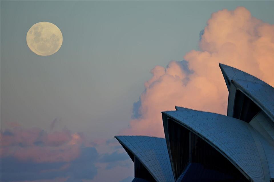 Ein blauer Mond ist über dem Opernhaus in Sydney zu sehen. Ein zweiter Vollmond in einem Monat wird als „Blue Moon“ bezeichnet.Gong Bing/XinHua/dpa