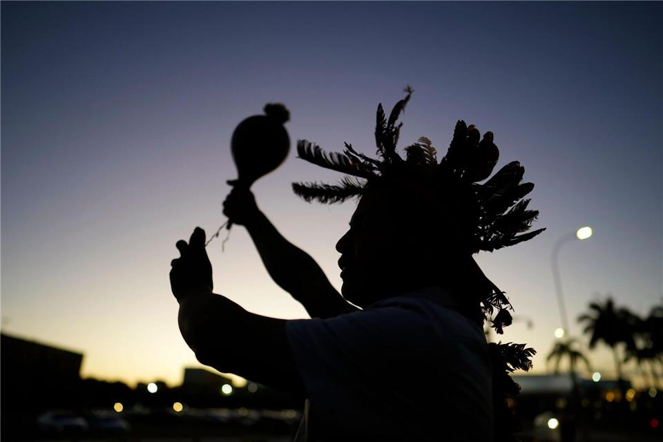 Ein indigener Mann führt während einer Demonstration ein Ritual durch.Eraldo Peres/AP/dpa
