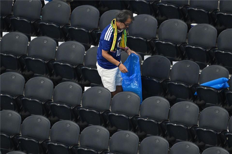 Ein japanischer Fan räumt den Müll weg beim WM-Spiel im Dallas-Stadion.Jessica Tobias/AP/dpa