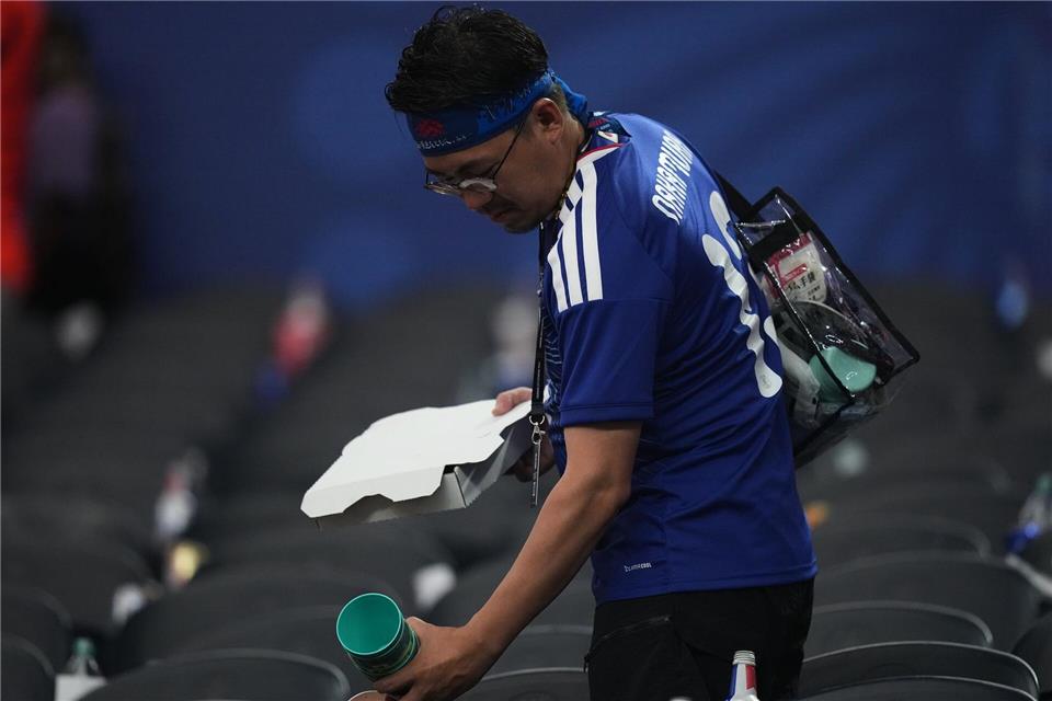Ein japanischer Fan sammelt nach dem WM-Gruppenspiel Müll ein.Julio Cortez/AP/dpa